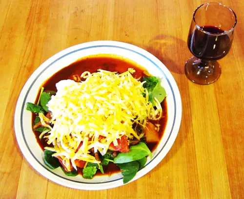 Plate filled with lettuce, taco meat sauce, fermented salsa, kefir cream cheese and chedder