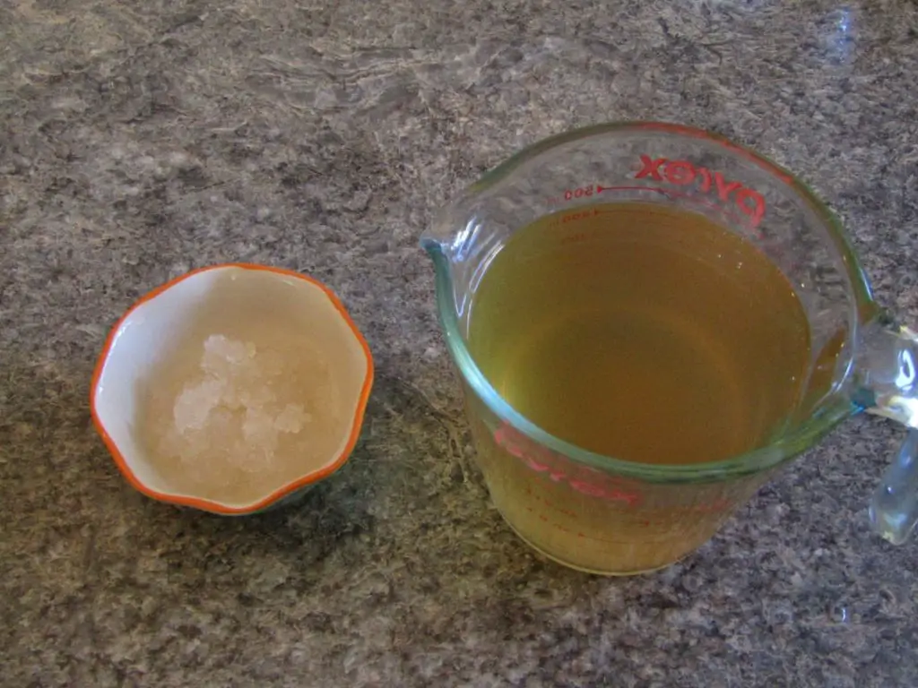 a bowl of water kefir grains and measuring cup full of kombucha culture